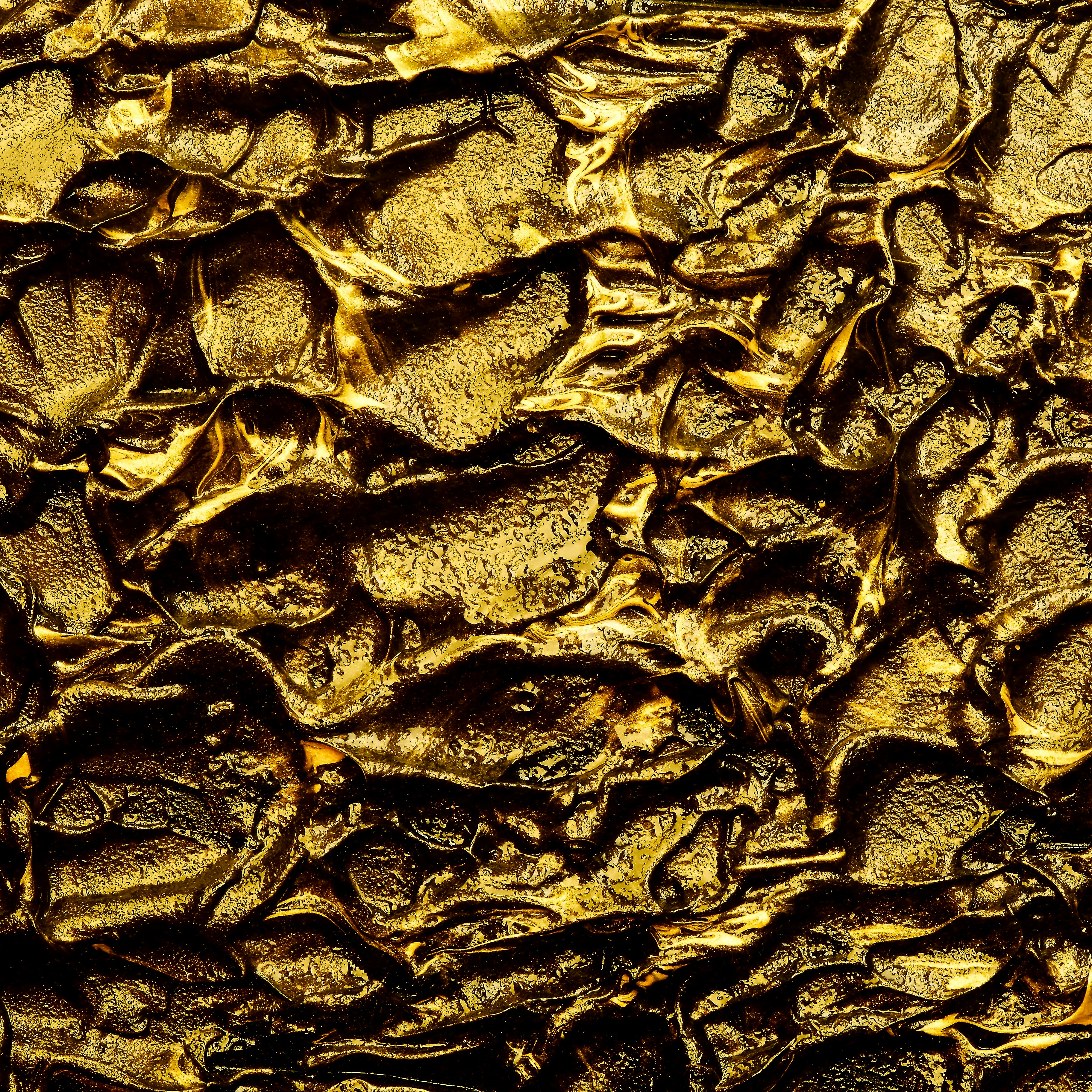 a close up of a textured surface with gold paint